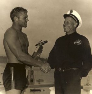 George 'Cap' Watkins presents Tommy Zahn with a paddle-boarding trophy.